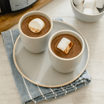 Two cups of hot chocolate topped with jumbo marshmallows.